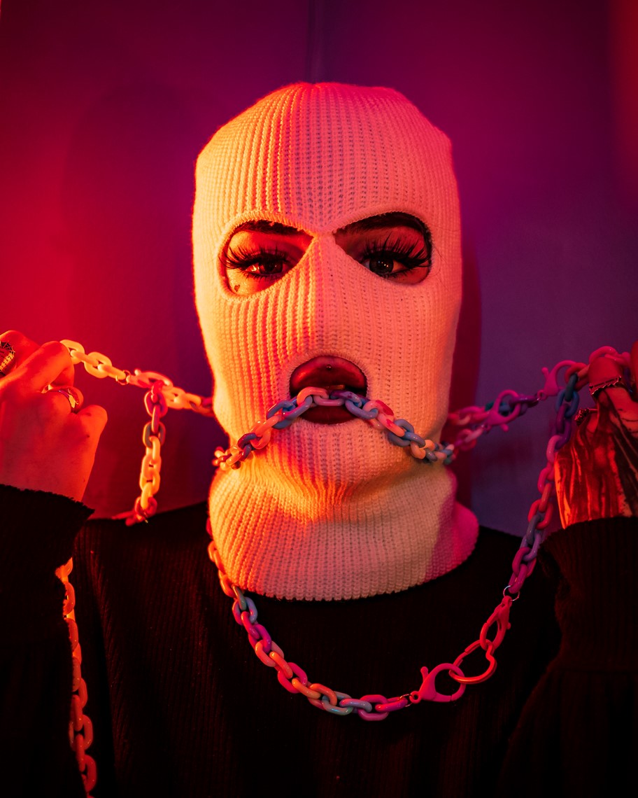person wearing a face mark, biting chains, kink, bondage