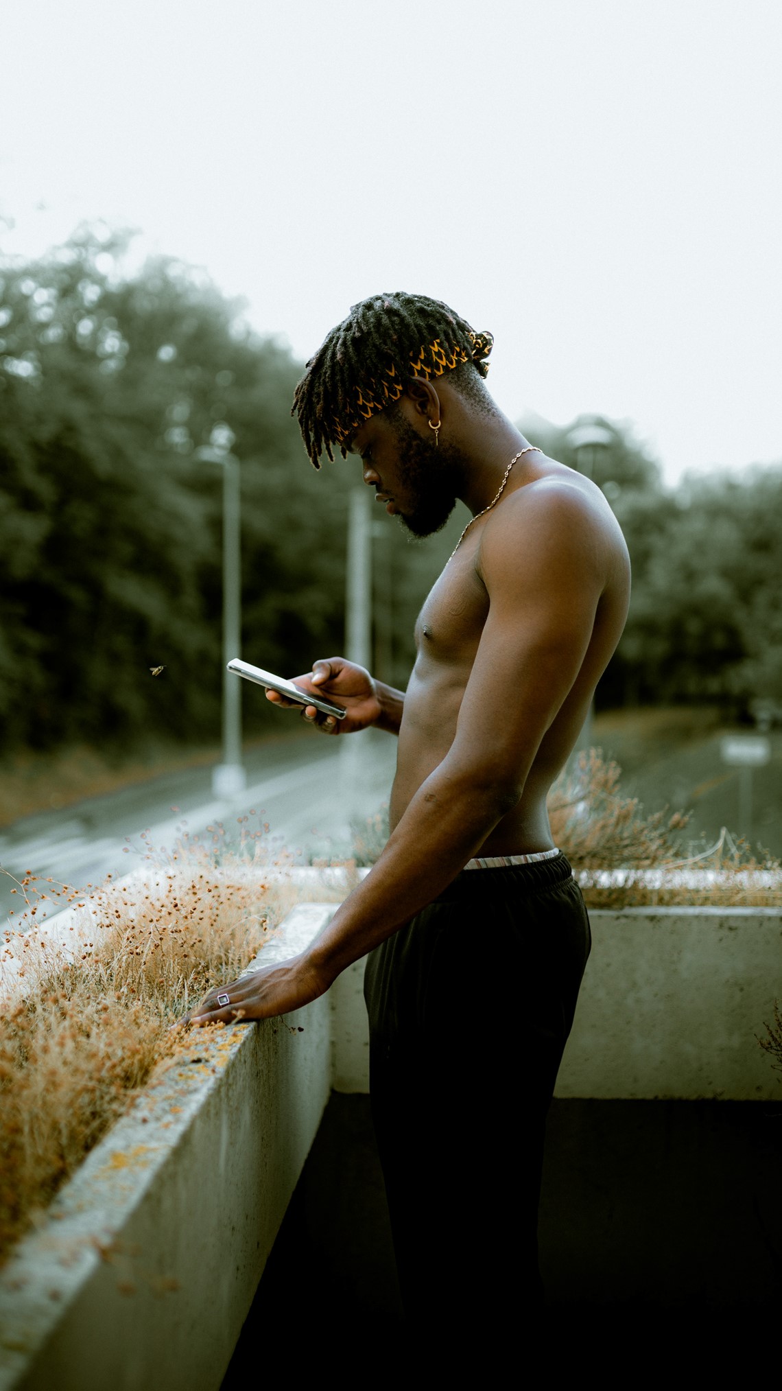 Shirtless man staring at their phone